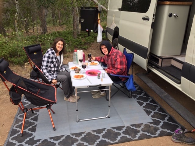 Enjoying a good meal while camping in their TOURIG Sprinter van