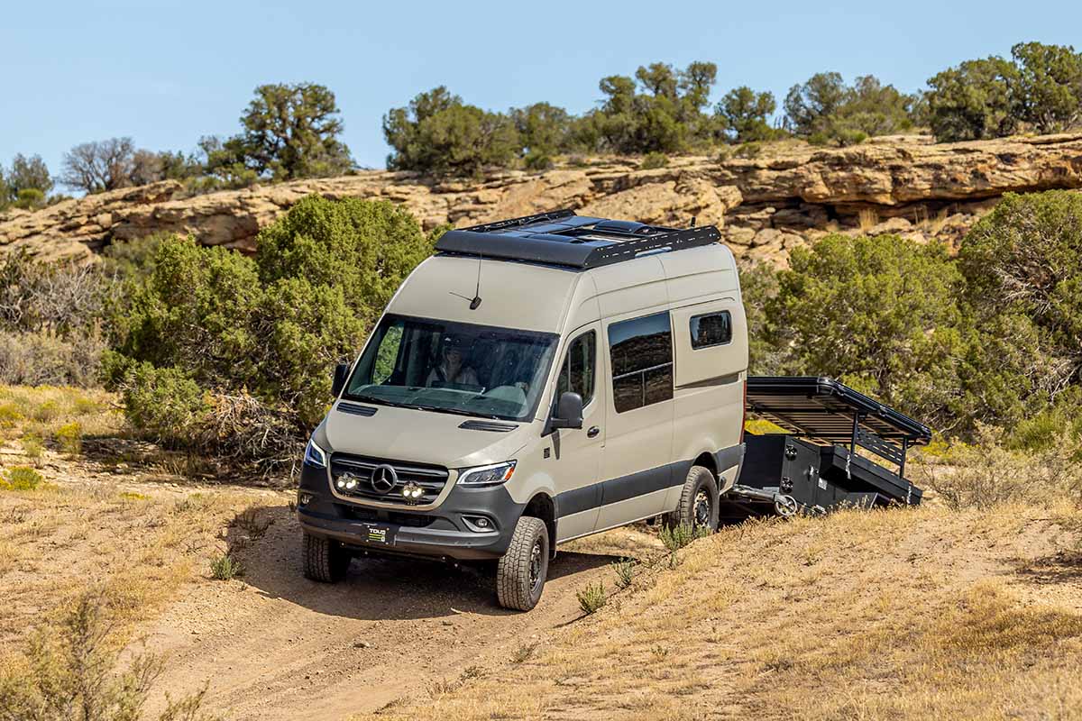 camper van with overland trailer off-roading